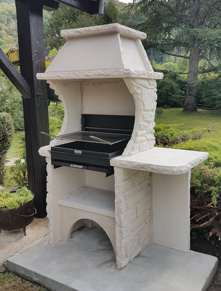 Beau barbecue en pierre avec cheminée et hotte intégrées.