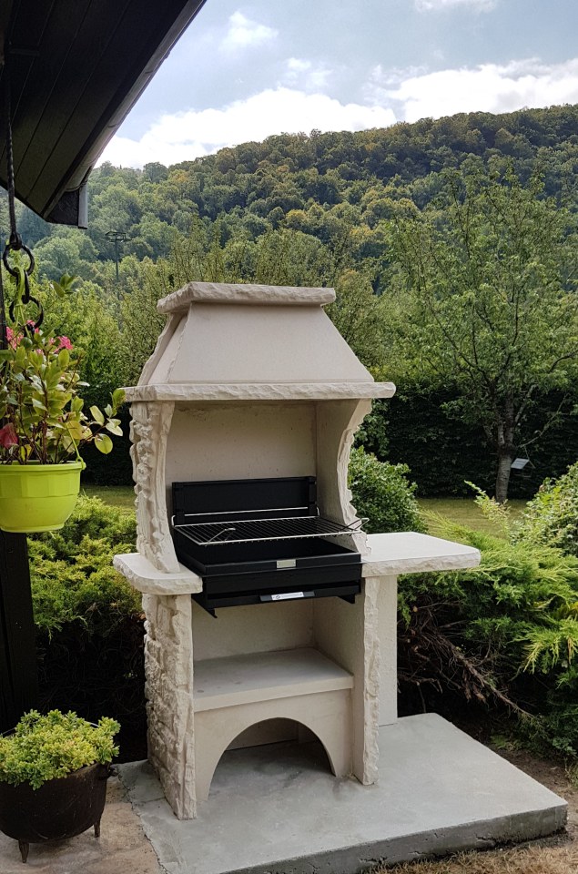 Barbecue en pierre reconstituee avec hotte et gril à foyer horizontal